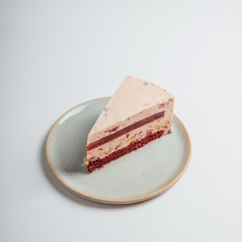 Strawberry Red Velvet Cheesecake slice served on a plate