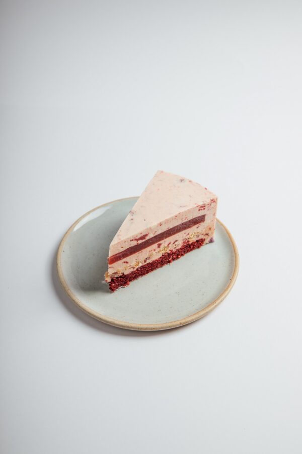Strawberry Red Velvet Cheesecake slice served on a plate