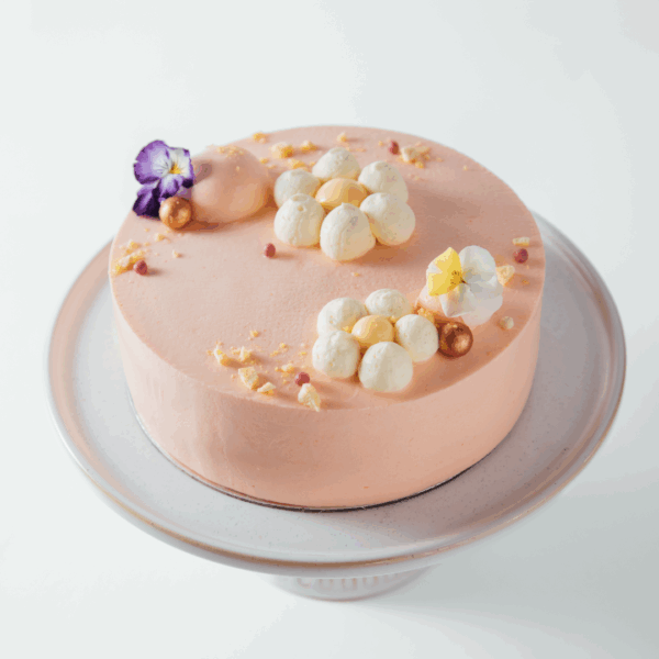 peach 1 Elegant pink cake with floral decorations on a cake stand.