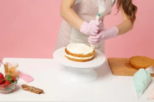 A woman in an apron frosting a cake