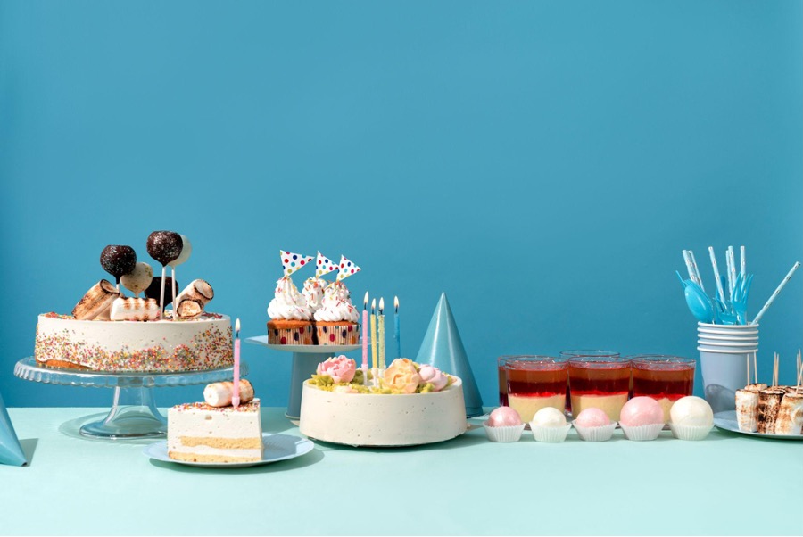 Assorted cakes and treats on blue-themed party table