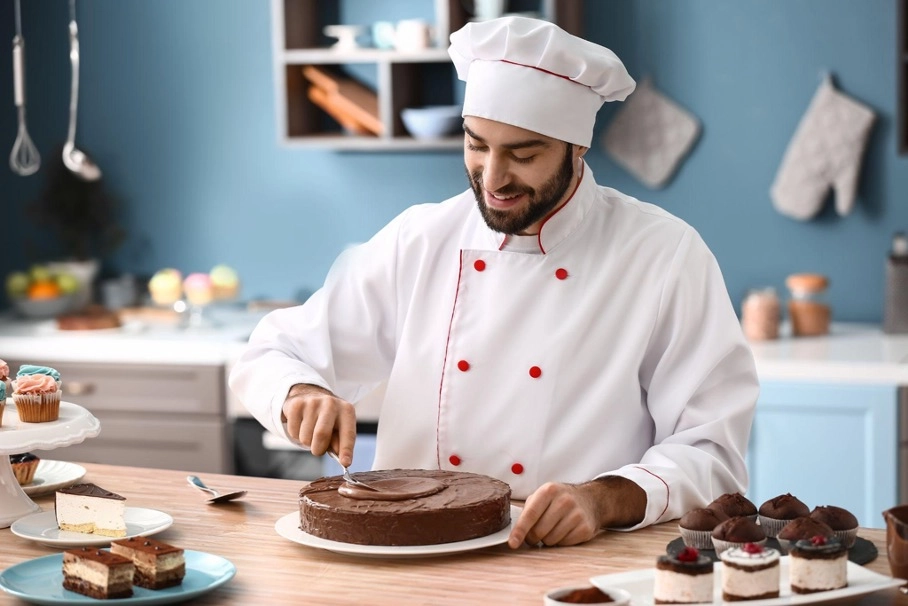 A pastry chef decorating a chocolate cake